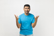 © khosrork - Portrait of sad frustrated attractive unshaven man wearing blue T- shirt standing raised his hands, screaming why, having stressed look. Indoor studio shot isolated on gray background.
