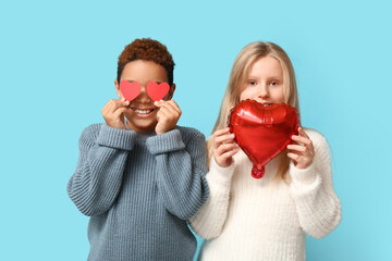 Wall Mural - Cute little children with red paper hearts and air balloon on blue background. Valentine's day celebration