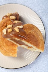 Poster - Supreme croissant with chocolate paste and nuts on grey table, top view. Tasty puff pastry