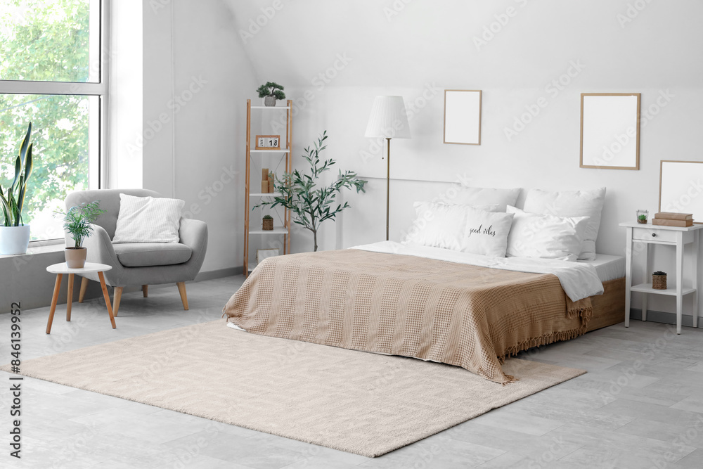 Cozy bed with white pillows in interior of light bedroom