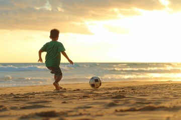 A young boy is playing soccer on the beach