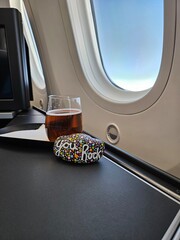 View out of first class travel passenger airplane window with you rock kindness rock and beer