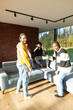 © Bjorn B - Four friends share a joyful moment in a modern living room, smiling and enjoying each others company in natural light