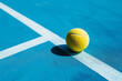 © Mirador - Single yellow tennis ball on a blue court, highlighting contrast and the dynamics of the sport.