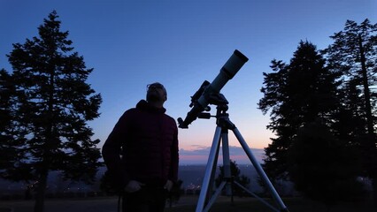 Wall Mural - amateur astronomer looking at the evening skies, observing planets, stars, moon and other celestial 