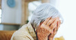 © peopleimages.com - Senior woman, mistake and depression with headache, stress or anixety on living room sofa at home. Closeup of elderly, sad female person or hands on face in fear for alzheimers, dementia or fatigue