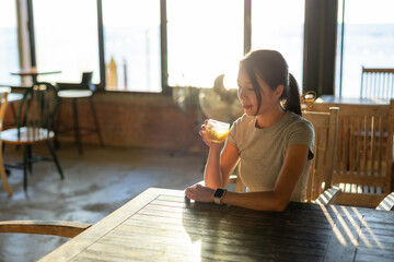 Wall Mural - Woman enjoy glass of iced tea at coffee shop