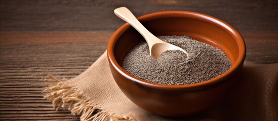 A healthy superfood chia seeds are displayed in a bowl with spoons against a brown textured background there is ample space for text or a copy space image