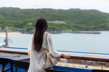 Canvas Print - Woman look at the sea at outdoor cafe