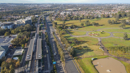 Canvas Print - Aerial drone view above Rouse Hill Station on the metro northwest railway line, Greater Sydney, NSW Australia as a train departs the station toward Kellyville in June 2024 