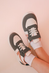 Wall Mural - Children's sneakers on a pink background, style and fashion