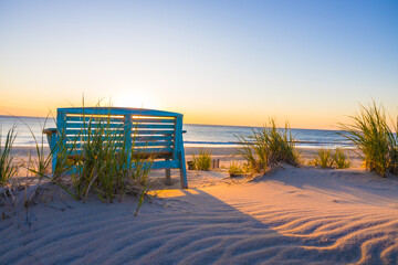 Wall Mural - Bench by sandy beach with sea grasses in Nags Head, North Carolina