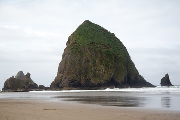 Sticker - three rock formations surrounded by water at the beach with surf