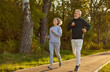 © Studio Romantic - Happy smiling sporty senior couple wearing sportswear jogging in the park having sport workout. Elderly man and woman running outdoors. Workout jog in nature, exercising for retired concept.