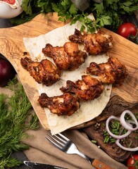 Wall Mural - Shot of skewers of grilled chicken with sliced onions on a white background