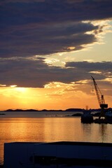 Poster - an orange and yellow sunset with a crane in the distance