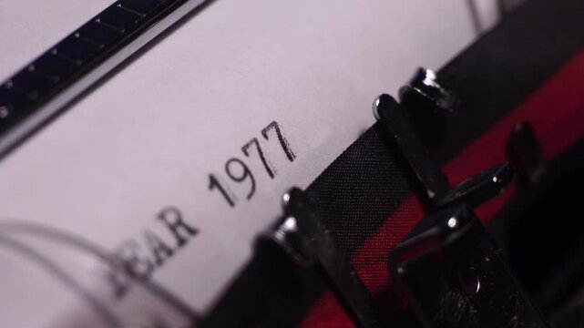 Year 1977, Typing in Vintage Typewriter on Blank White Paper, Close Up