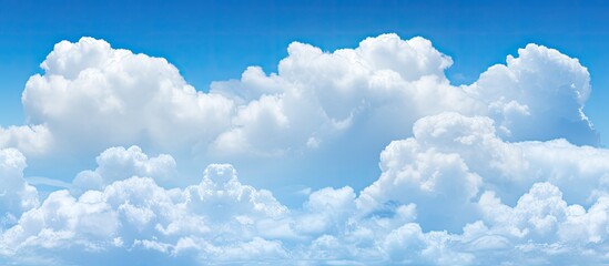 Poster - Copy space image of stunning billowing clouds contrasting with a vibrant blue sky