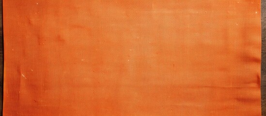 Poster - Top down view of a wooden framed copy space image on a smooth orange linen fabric creating a natural textile background with a textured appearance