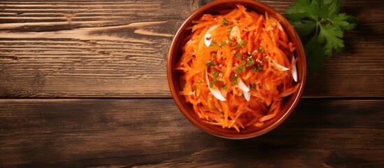 Poster - Top view of a bowl filled with a Korean pickled carrots salad placed on a wooden background with copy space image