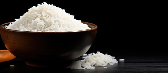 Poster - Bowl of white rice with ear on dark black table copy space image
