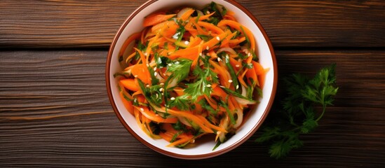 Poster - Top view of a bowl filled with a Korean pickled carrots salad placed on a wooden background with copy space image