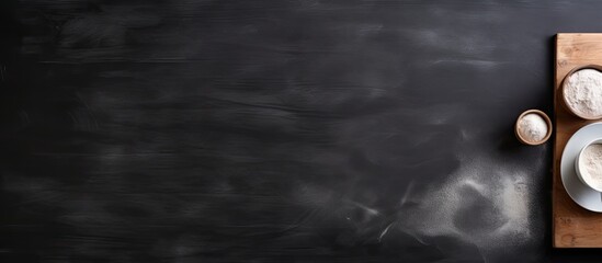Poster - Top view of a black ceramic table with a rolling pin and starch providing a copy space image for text on the side