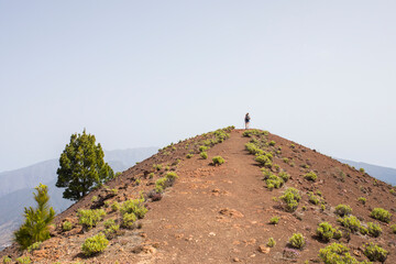 Wall Mural - A young woman walking towards Birigoyo peak, La Palma Island, Canary Islands.