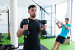 © ADDICTIVE STOCK - Two men training hard in a modern gym with fitness equipment