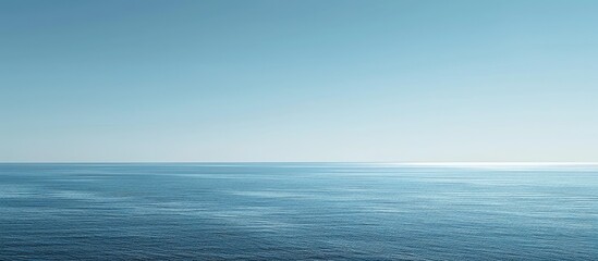 Vast blue ocean and a cloudless sky with room for text.