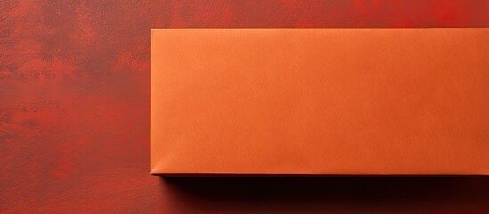 Poster - Vibrant red abstract paper texture background with an old Kraft paper box showcasing an orange craft pattern, viewed from the top, against an active color backdrop with copy space image.
