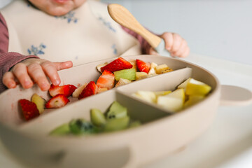 Wall Mural - Baby eats food independently using self-feeding method, blw,