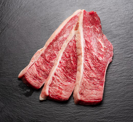 Wall Mural - Sliced picanha beef on a gray stone serving board top view. Traditional Portuguese food.