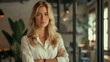© standret - Confident blond businesswoman standing with crossed arms in office