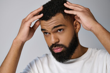 Wall Mural - African american bearded young man holding a bottle of locion.