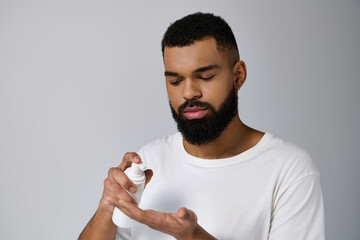 Wall Mural - African american handsome young man holding a bottle of locion.