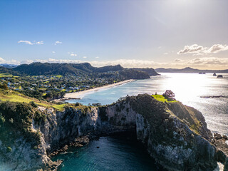 Wall Mural - aerial view of coastline of steep chalk like rock on sunny day. te pare point, with beach town of ha
