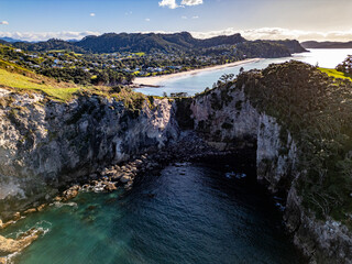 Wall Mural - aerial view of cove made from white limestone cliffs on sunny day. te pare point, with beach town of