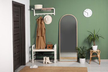 Poster - Stylish hallway with shoe storage bench and mirror near sage green wall. Interior design