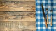 © TheWaterMeloonProjec - Top view of light wooden table with blue checkered tablecloth knife fork and space for text
