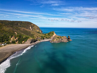 Wall Mural - aerial view over auckland coastline piha black sand beach with rocky outcrop.