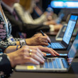 © AIRina - A close-up image of a conference attendee's hands typing on a laptop, emphasizing focus and productivity during a professional event or meeting