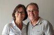 © Markus Schröder - Portrait of a joyful caucasian couple in their 50s wearing a sporty polo shirt in front of minimalist or empty room background