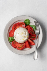 Wall Mural - Burrata cheese with tomatoes. Caprese salad in bowl on light background top view