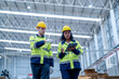 © ultramansk - Male and female engineers in neat work clothes prepare and control the production system of large modern machines in a factory producing industrial technology products.