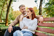 © LIGHTFIELD STUDIOS - A man and woman in casual attire sit peacefully together on a park bench.