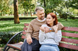 © LIGHTFIELD STUDIOS - A man and woman in casual attire sit together on a park bench, enjoying each others company.