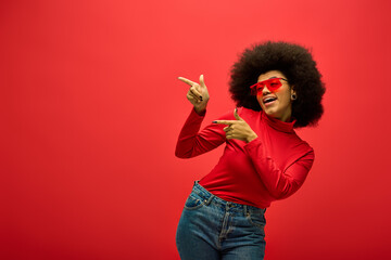 stylish african american woman striking a pose in trendy red shirt and sunglasses.