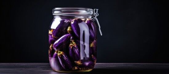 Poster - Glass jar filled with pickled eggplant placed on a table in a close-up view. with copy space image. Place for adding text or design