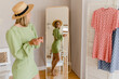 © mary_markevich - young pretty woman in green dress trying on style trend dress looking in mirror
